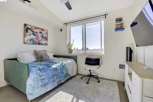 a bedroom with a bed and flat tv screen on the dresser