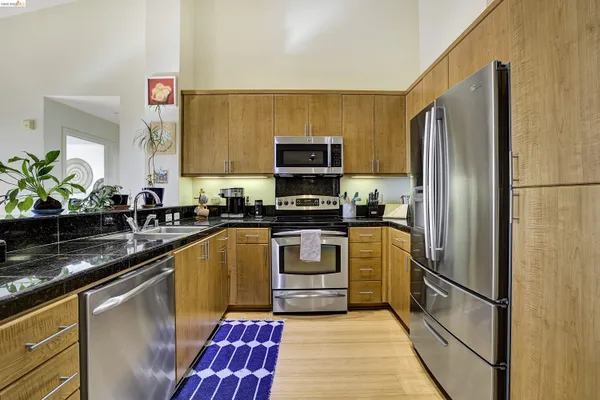 a kitchen with stainless steel appliances a refrigerator and a stove top oven