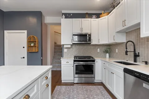 a kitchen with cabinets appliances and a sink