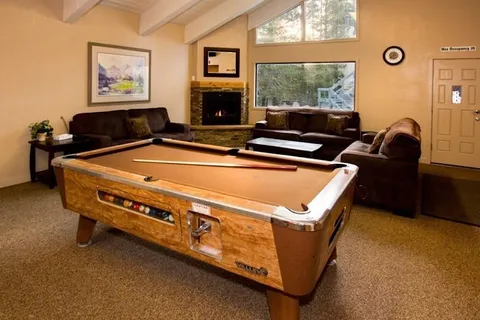 a living room with furniture pool table and a fireplace