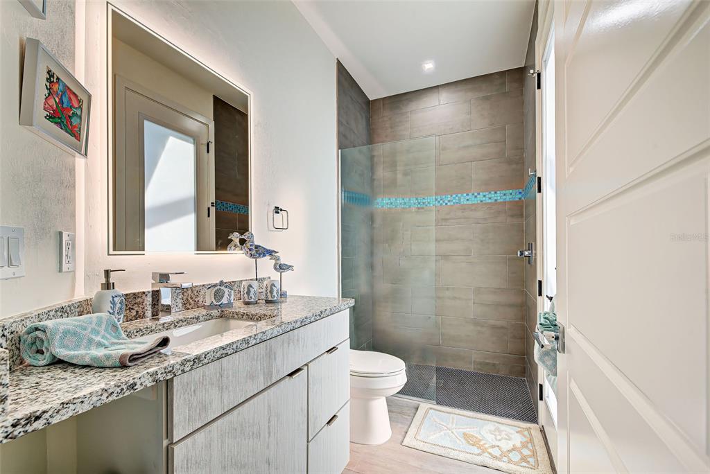 19 Windward Road Placida, FL 33946 - Photo 48 of 56 a bathroom with a granite countertop sink toilet a mirror and shower