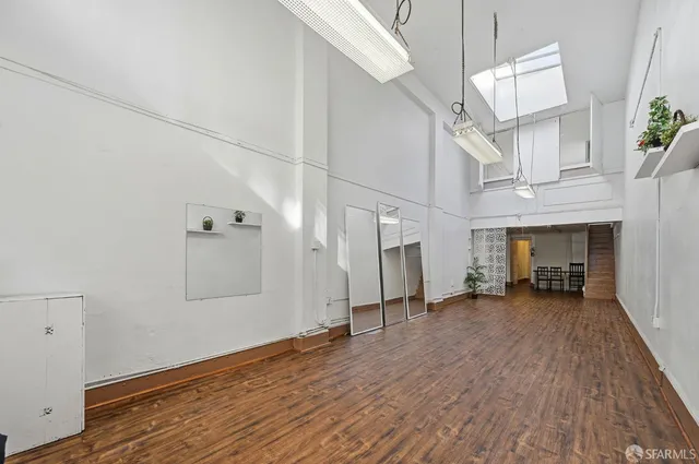 a view of empty room with wooden floor and window
