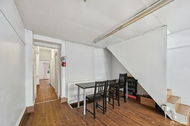 a walk in closet with wooden floor