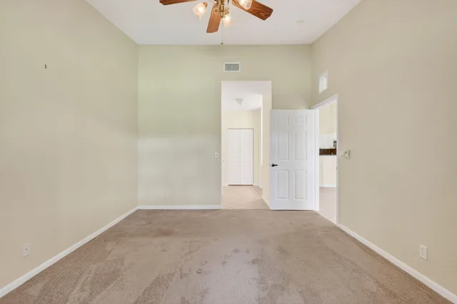 an empty room with windows and fan