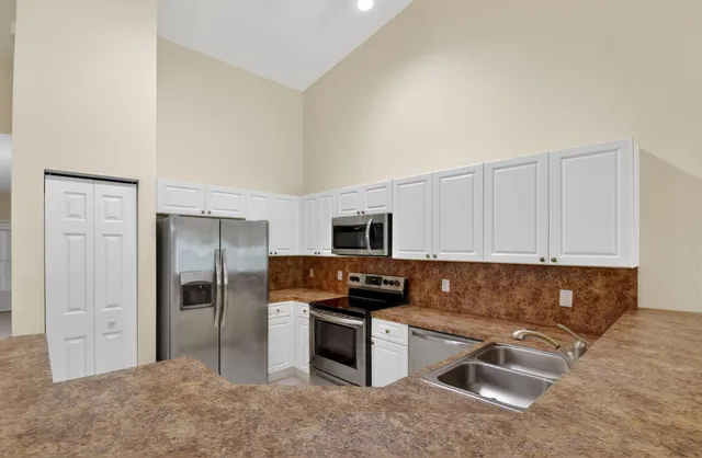 a kitchen with cabinets stainless steel appliances and a sink