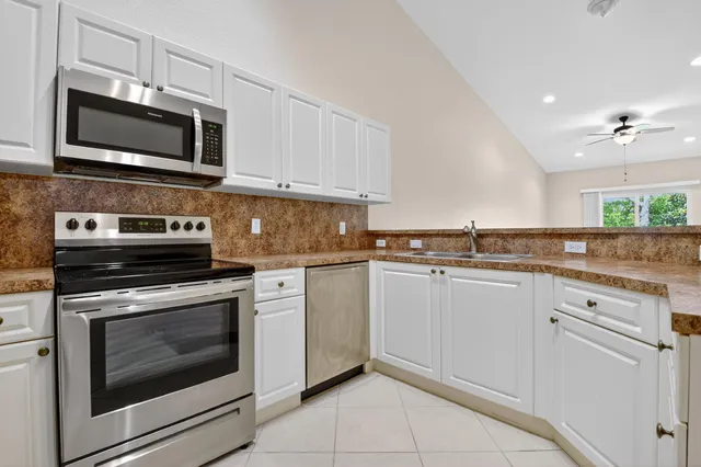 a kitchen with stainless steel appliances granite countertop a refrigerator and a stove top oven