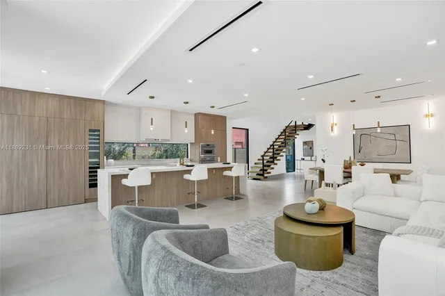 a large white kitchen with stainless steel appliances kitchen island granite countertop a large counter top stainless steel appliances and cabinets