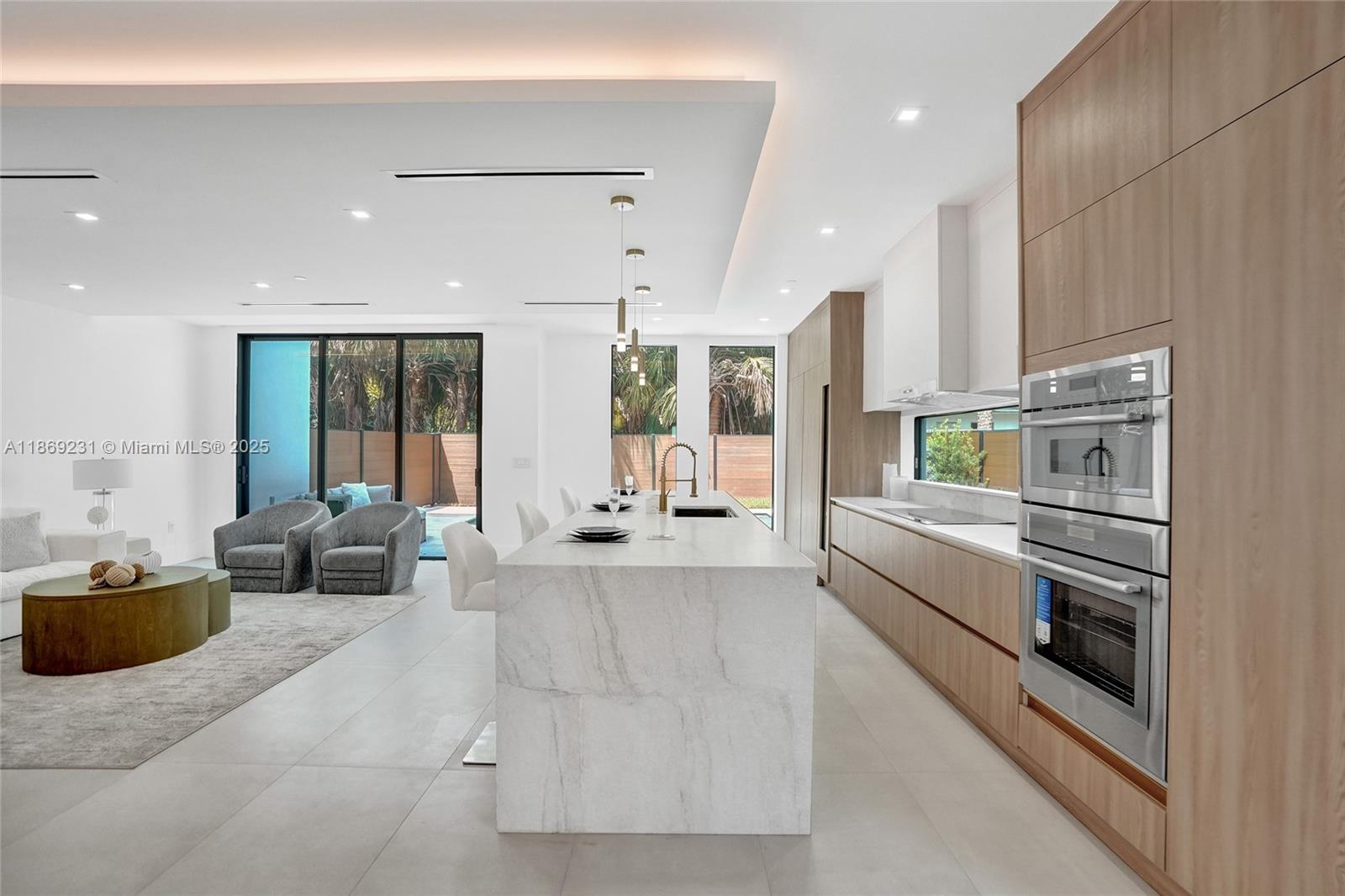 1825 Northeast 26th Avenue, Unit C Fort Lauderdale, FL 33305 - Photo 26 of 90 a large white kitchen with stainless steel appliances kitchen island granite countertop a large counter top stainless steel appliances and cabinets