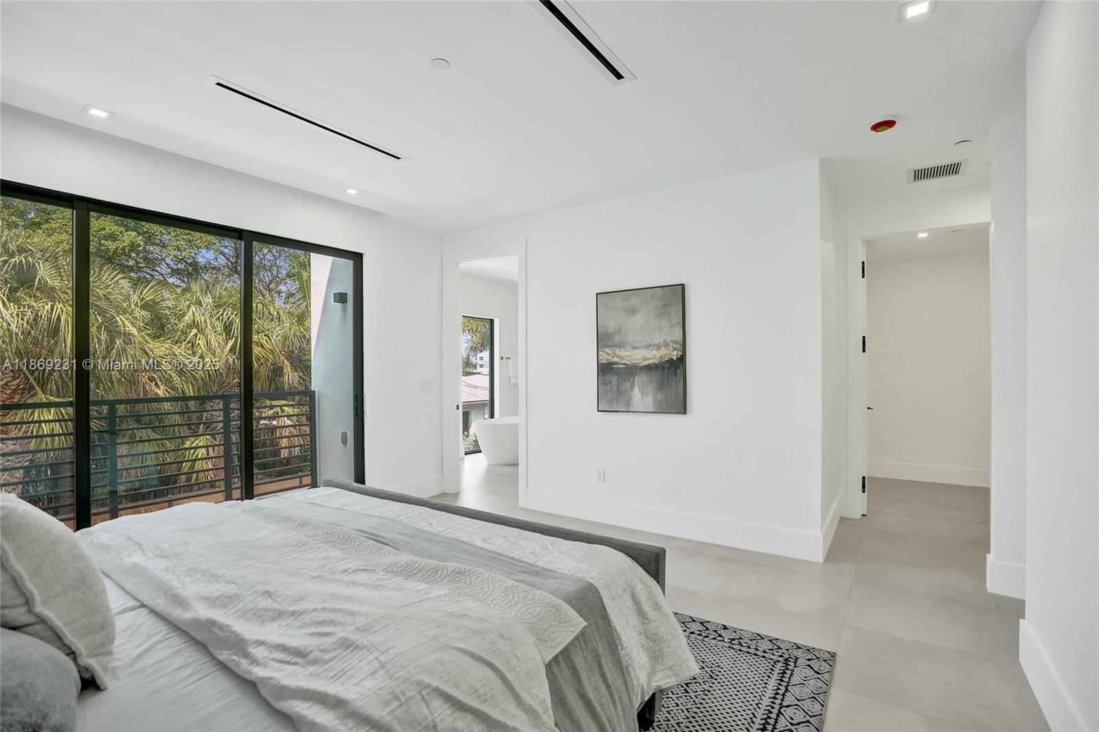 1825 Northeast 26th Avenue, Unit C Fort Lauderdale, FL 33305 - Photo 48 of 90 a bedroom with a large bed and a large window