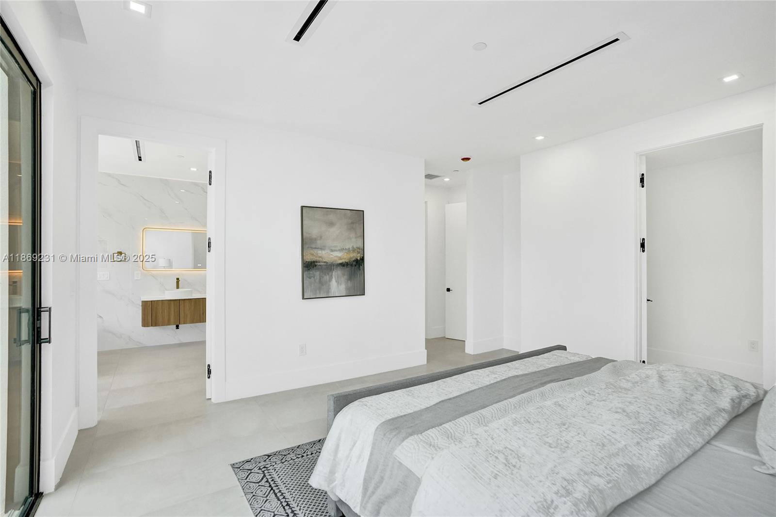 1825 Northeast 26th Avenue, Unit C Fort Lauderdale, FL 33305 - Photo 49 of 90 a bedroom with a bed and a view of bathroom