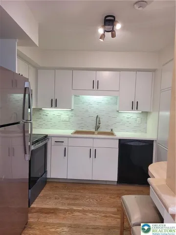 a kitchen with granite countertop a sink stainless steel appliances and cabinets