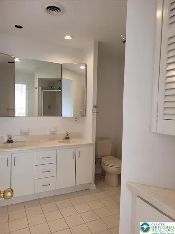 a bathroom with a double vanity sink and a toilet