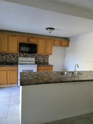 a kitchen with granite countertop a sink and a stove top oven