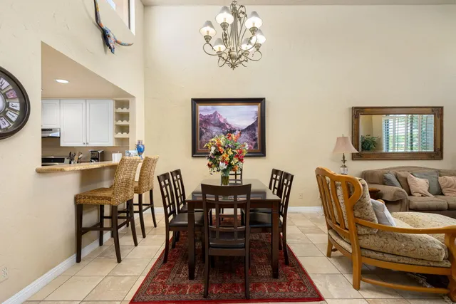 a living room with furniture floor to ceiling window and a flat screen tv
