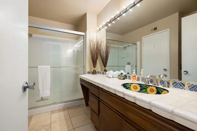 a patio with table and chairs potted plants and a large tree