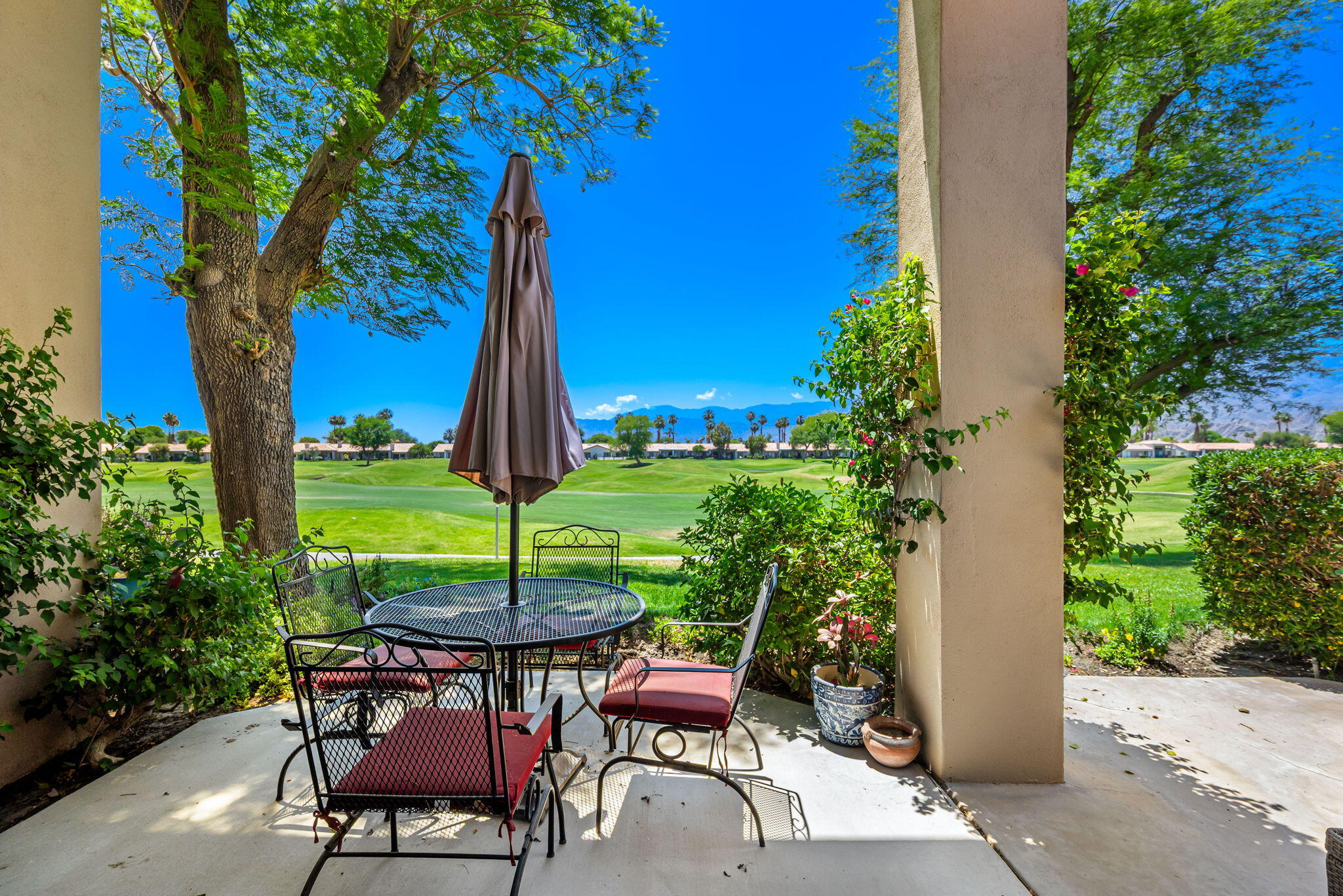 80601 Oak-Tree La Quinta, CA 92253 - Photo 37 of 64 a patio with table and chairs potted plants and a large tree