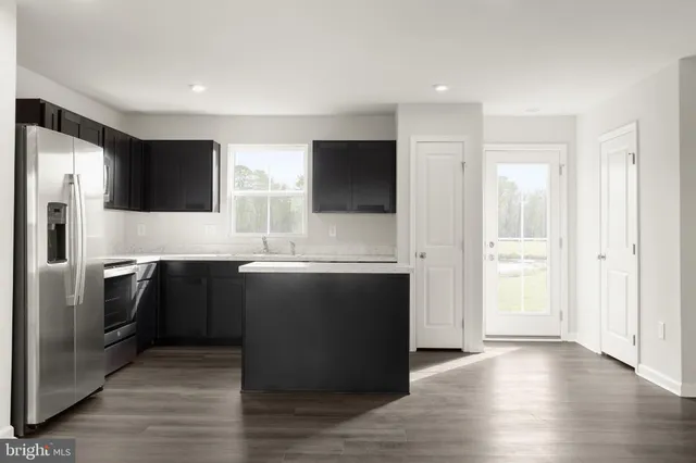 a kitchen with stainless steel appliances granite countertop a refrigerator and a stove top oven