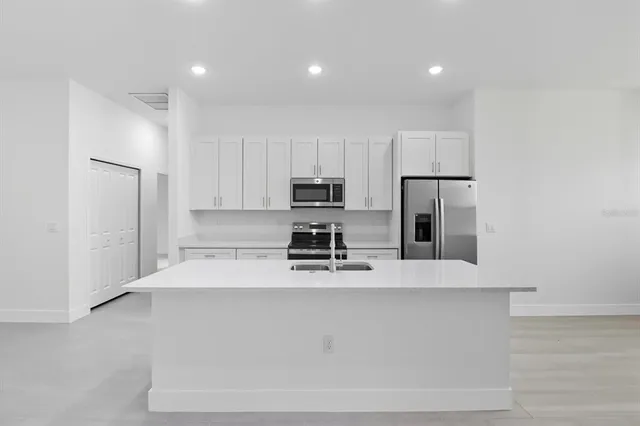 a kitchen with stainless steel appliances granite countertop white cabinets and a stove