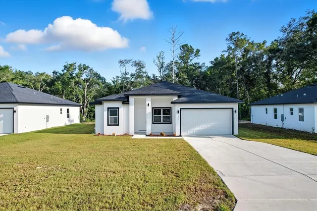 a front view of a house with yard and trees