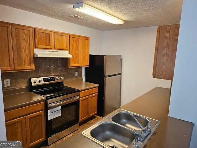 a kitchen with wooden cabinets and a stove top oven