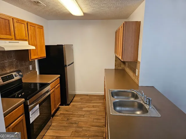 a kitchen with a sink stove and refrigerator