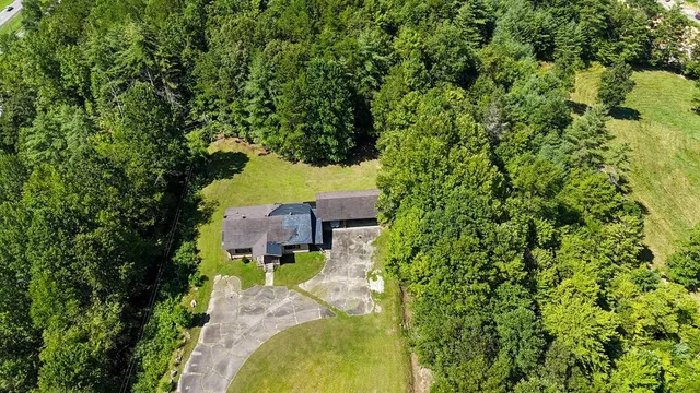 an aerial view of a house with a yard swimming pool and garden