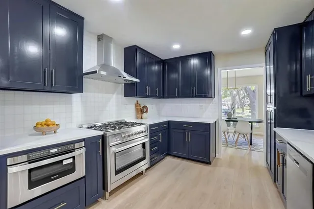 a large kitchen with stainless steel appliances lots of counter top space