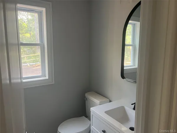 a white toilet sitting next to a window in a bathroom