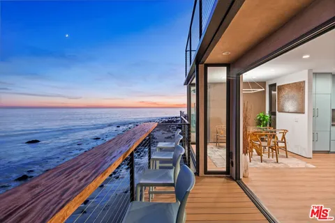 a view of a balcony with wooden floor and outdoor seating