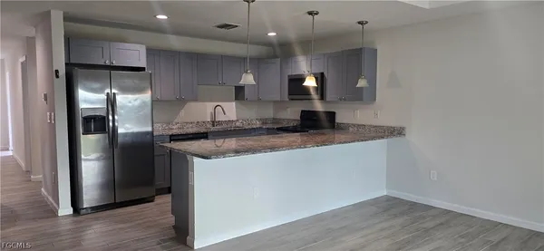 a kitchen with stainless steel appliances granite countertop a refrigerator a sink and a oven