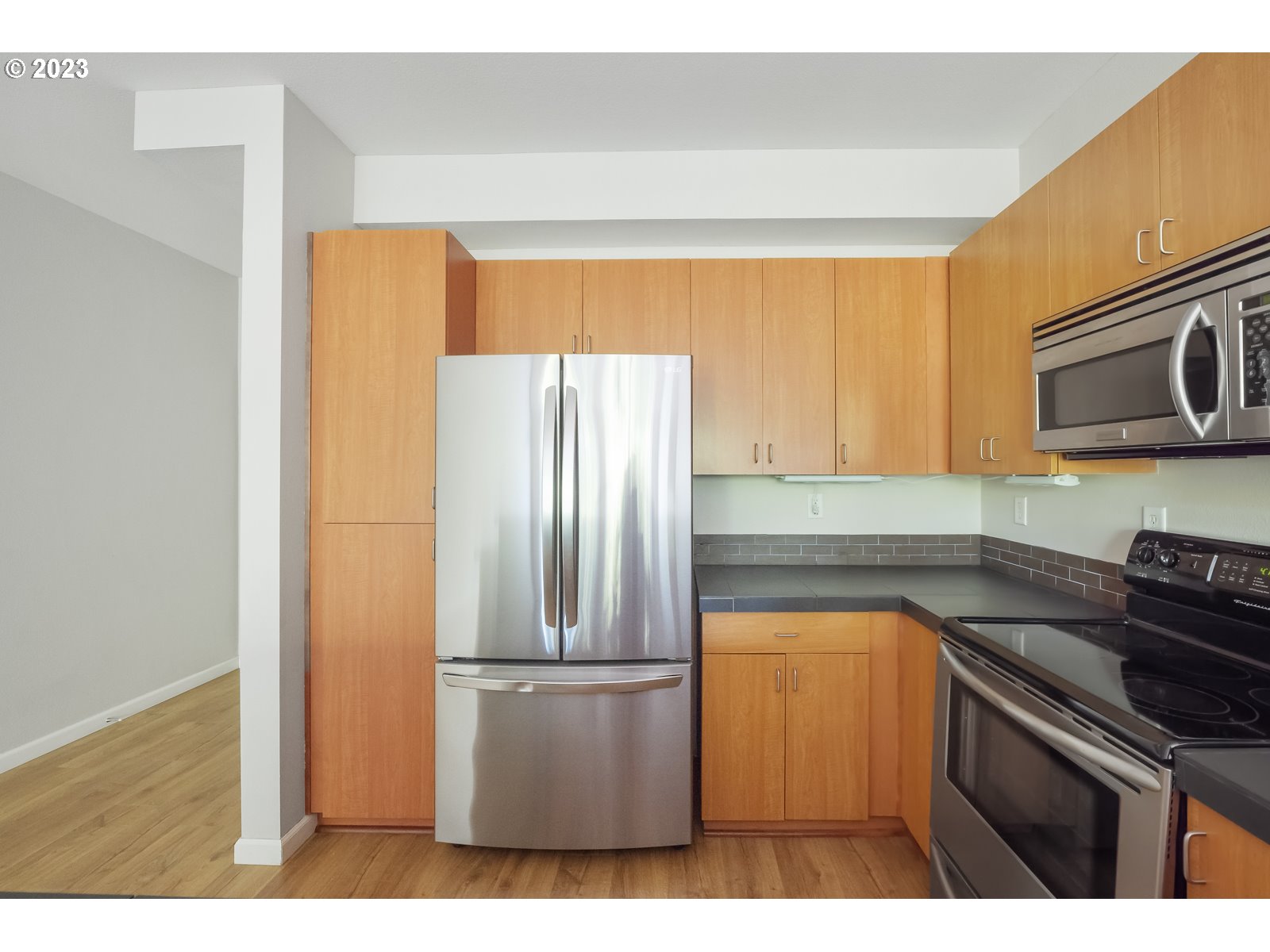8712 North Decatur Street, Unit 201 Portland, OR 97203 - Photo 14 of 40 a kitchen with a refrigerator and a stove top oven