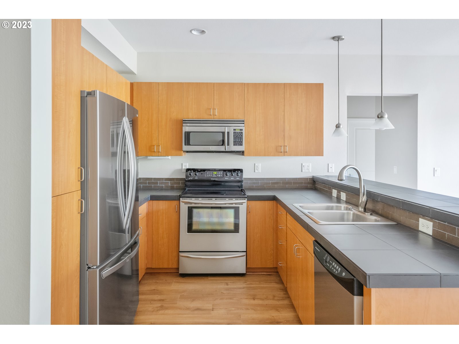 8712 North Decatur Street, Unit 201 Portland, OR 97203 - Photo 15 of 40 a kitchen with stainless steel appliances granite countertop a sink stove and refrigerator