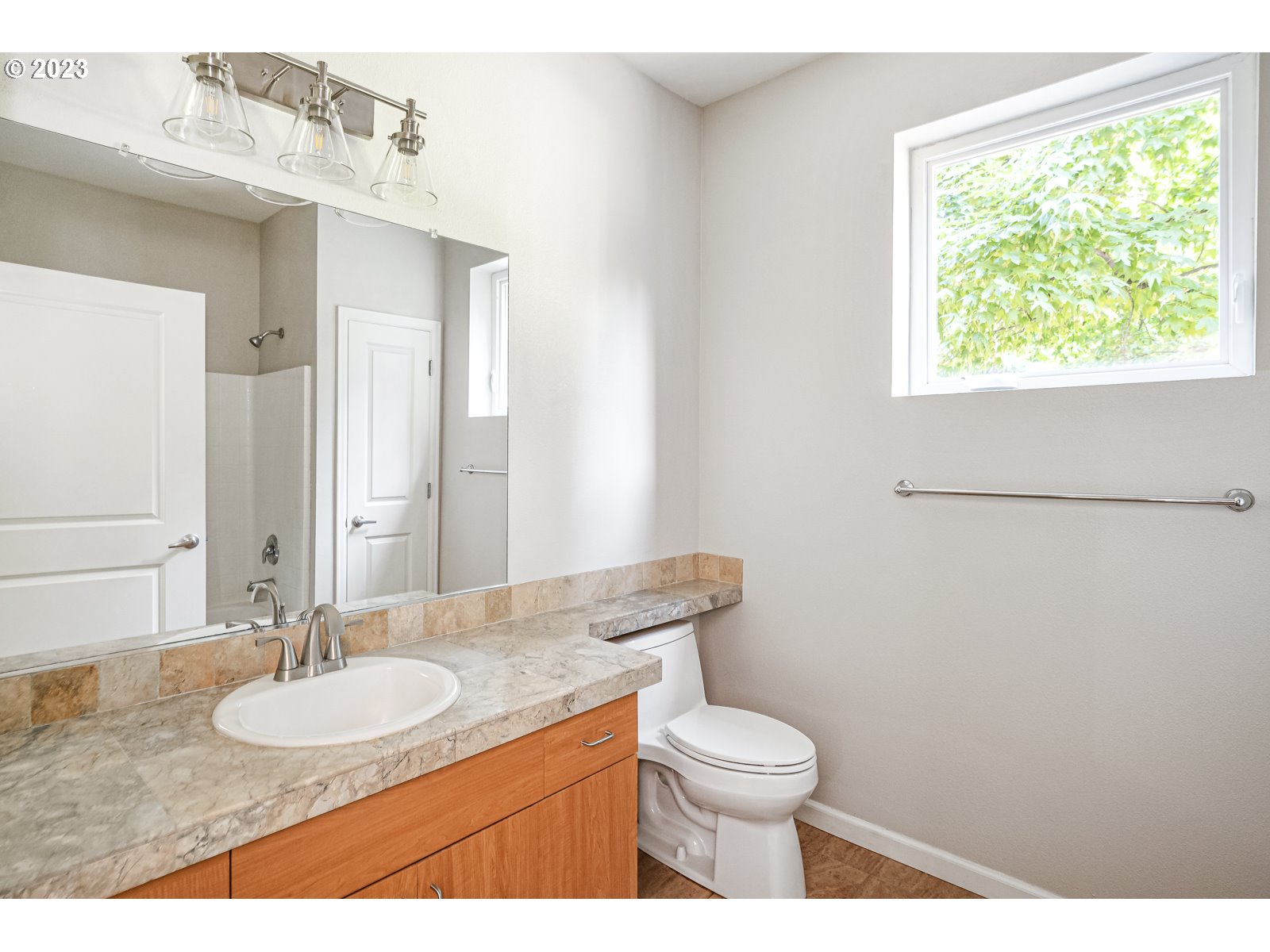 8712 North Decatur Street, Unit 201 Portland, OR 97203 - Photo 22 of 40 a bathroom with a granite countertop sink toilet a mirror and a window