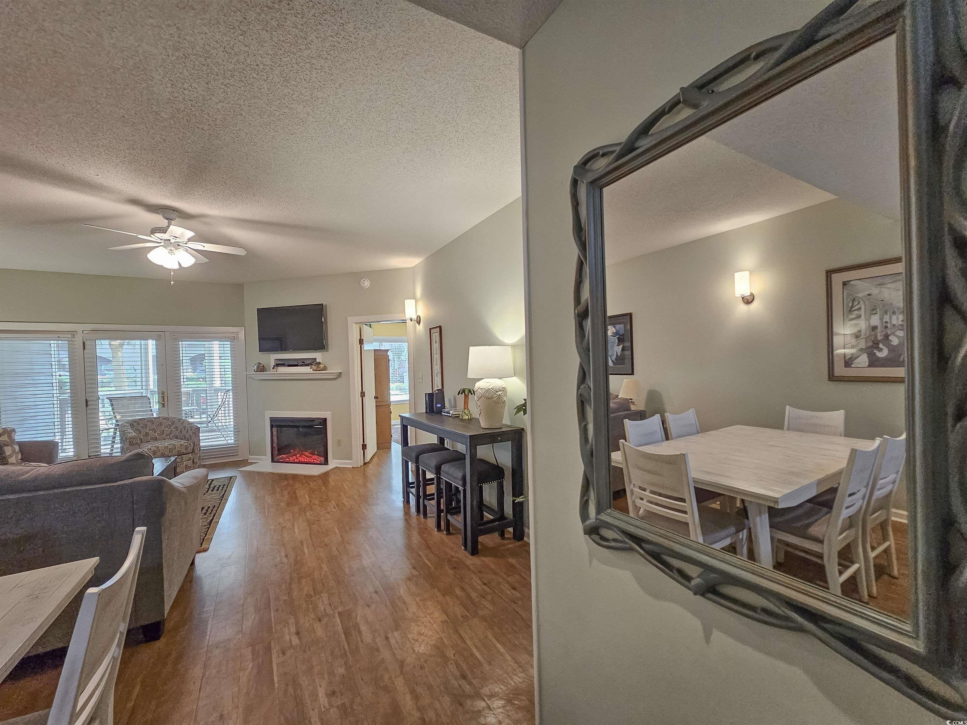 709 Appleby Way, Unit 7C Myrtle Beach, SC 29572 - Photo 5 of 40 Living area featuring LVP floors, a glass covered, electric fireplace, and a ceiling fan