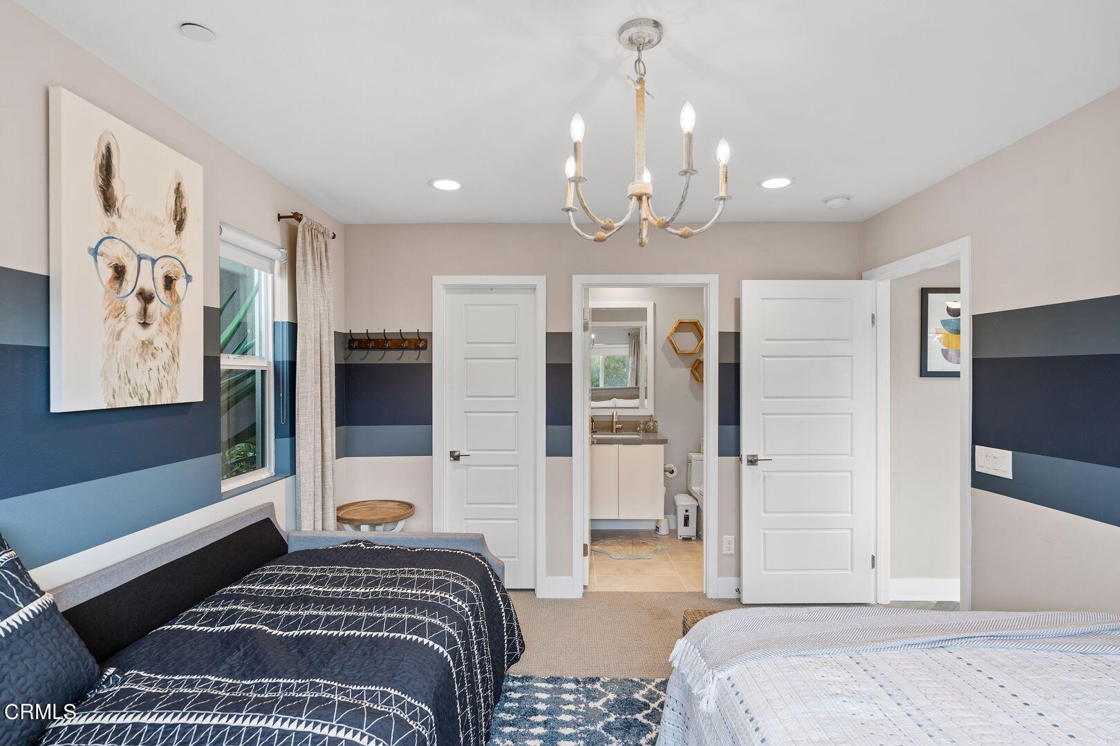 1028 Harbor Boulevard Oxnard, CA 93035 - Photo 11 of 48 a bedroom with a large bed and a chandelier