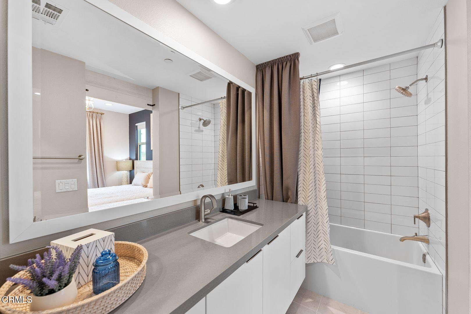 1028 Harbor Boulevard Oxnard, CA 93035 - Photo 16 of 48 a bathroom with a tub a sink and a large mirror