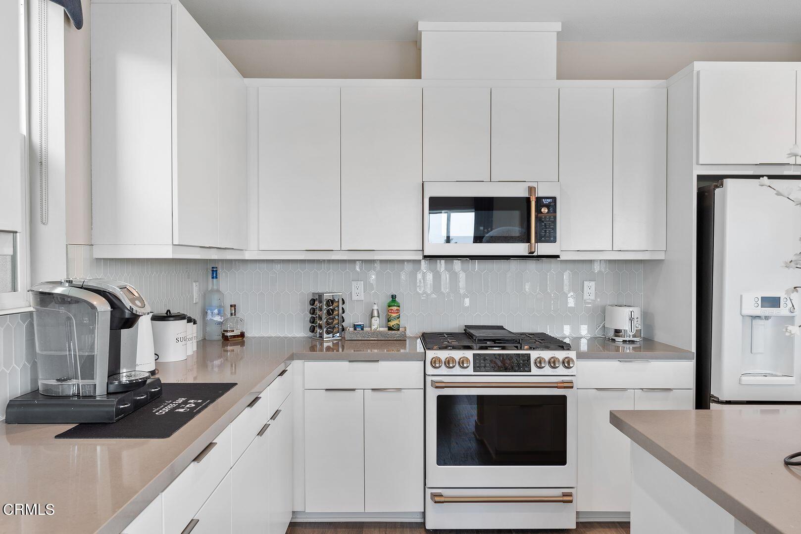 1028 Harbor Boulevard Oxnard, CA 93035 - Photo 25 of 48 a kitchen with granite countertop white cabinets and white appliances