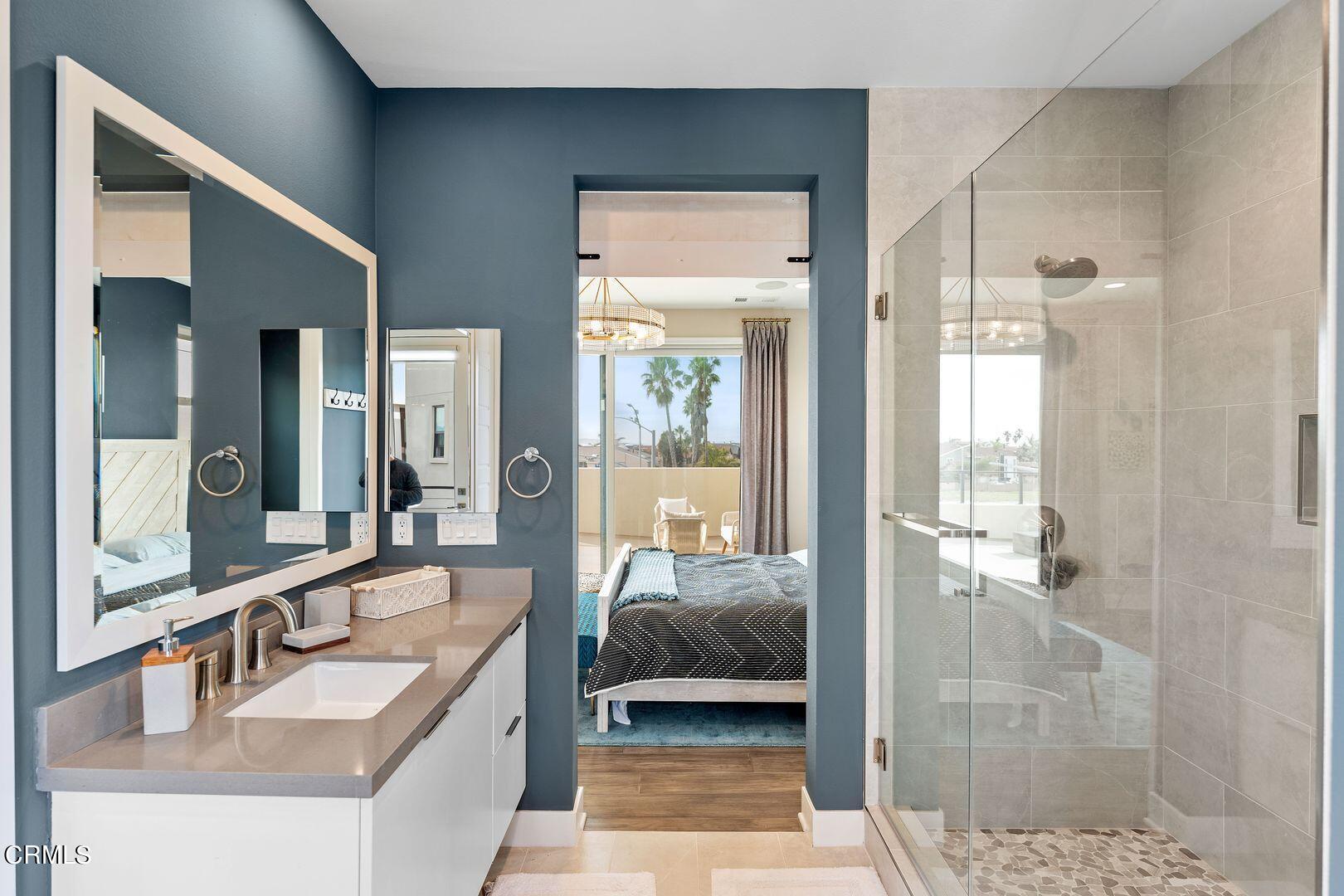 1028 Harbor Boulevard Oxnard, CA 93035 - Photo 37 of 48 a en suite bathroom with a sink a large mirror and a glass door shower