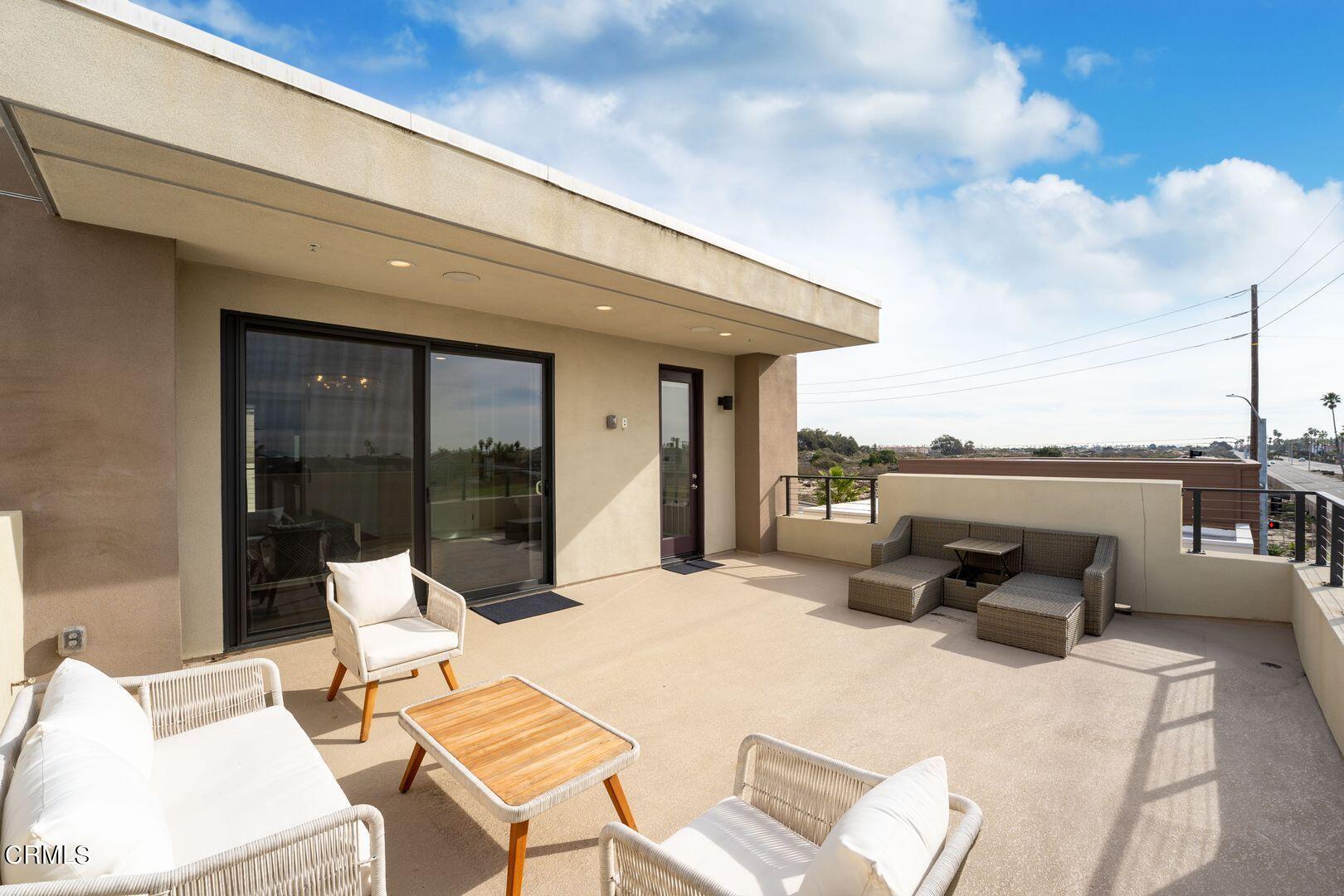 1028 Harbor Boulevard Oxnard, CA 93035 - Photo 41 of 48 a roof deck with table and chairs and potted plants