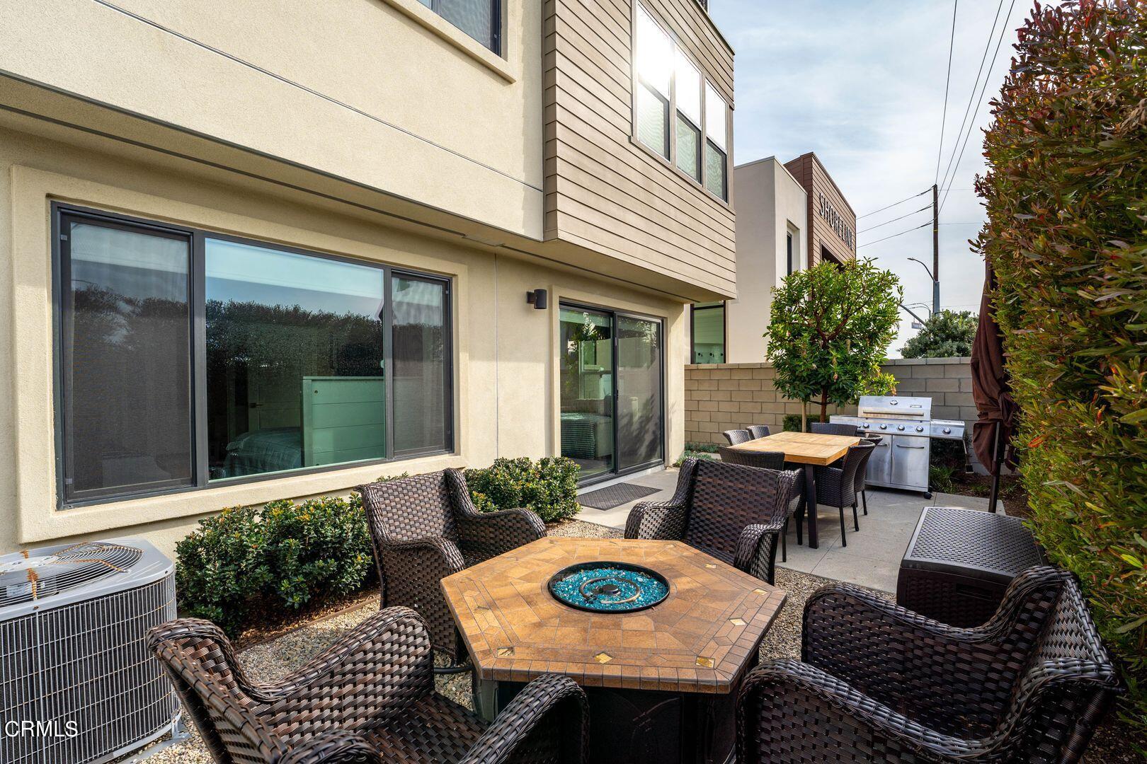 1028 Harbor Boulevard Oxnard, CA 93035 - Photo 44 of 48 a view of a patio with table and chairs potted plants and floor to ceiling window