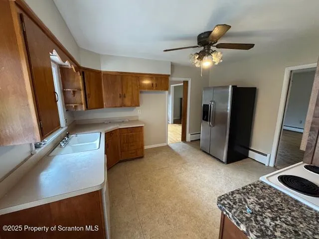 a living room with stainless steel appliances furniture a rug and a window