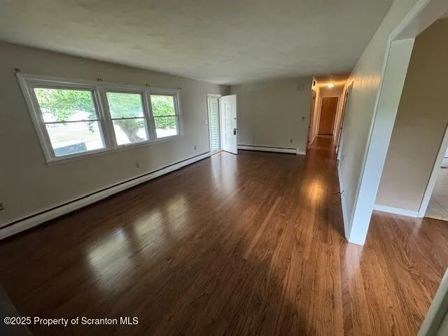 a view of a room with wooden floor and window