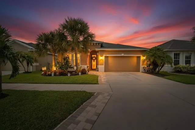 a front view of a house with a yard and palm tree