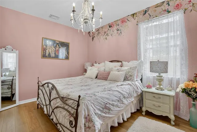 a bedroom with a large bed and a chandelier