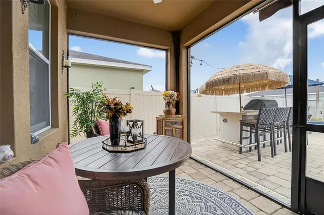 a view of a patio with dining table and chairs with wooden floor