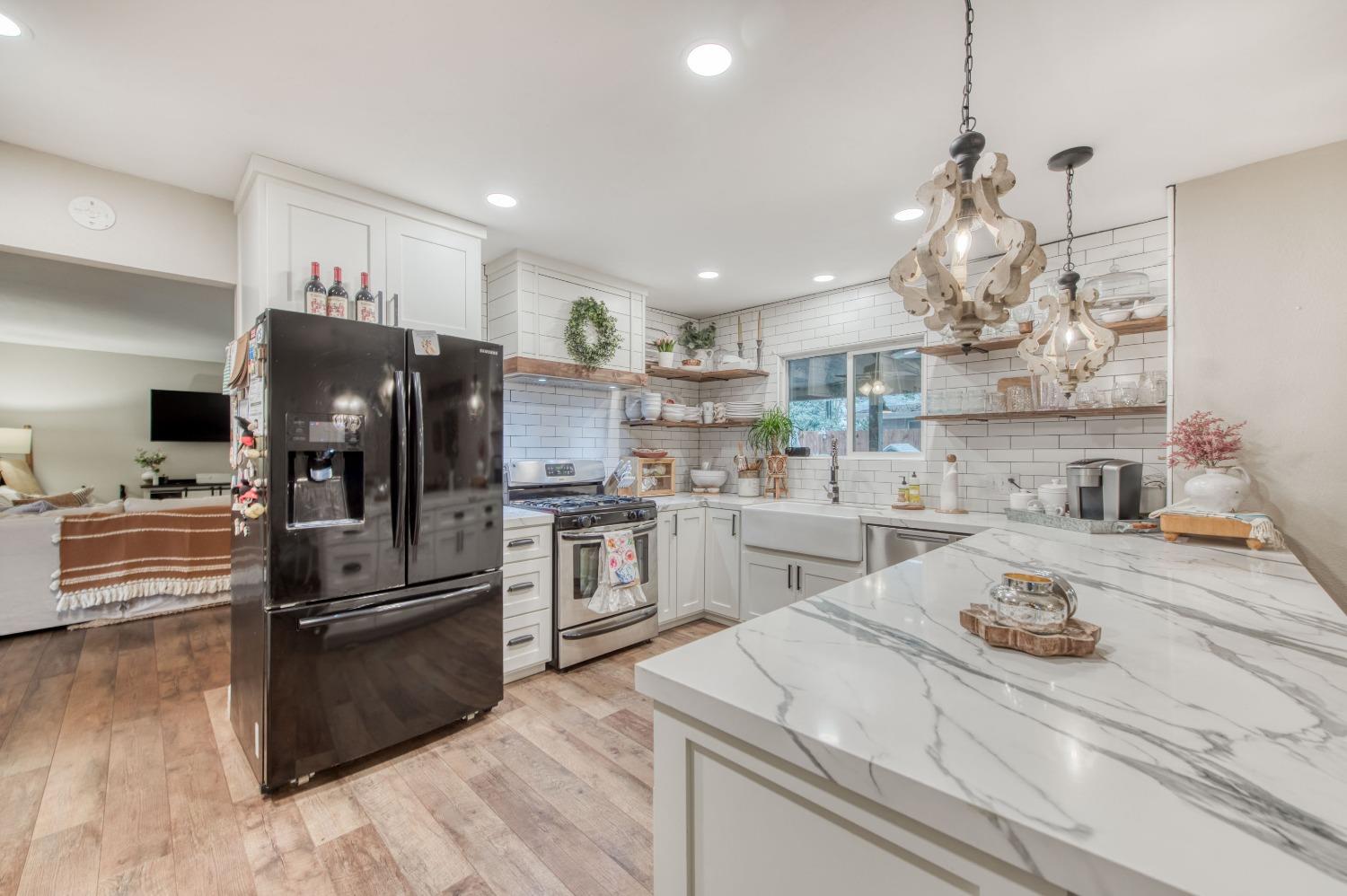 1880 East Cardella Street Firebaugh, CA 93622 - Photo 12 of 42 a kitchen with a refrigerator a stove and a sink with wooden floor