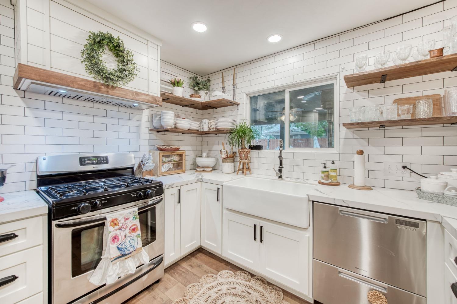 1880 East Cardella Street Firebaugh, CA 93622 - Photo 15 of 42 a kitchen with stainless steel appliances a stove a sink and cabinets