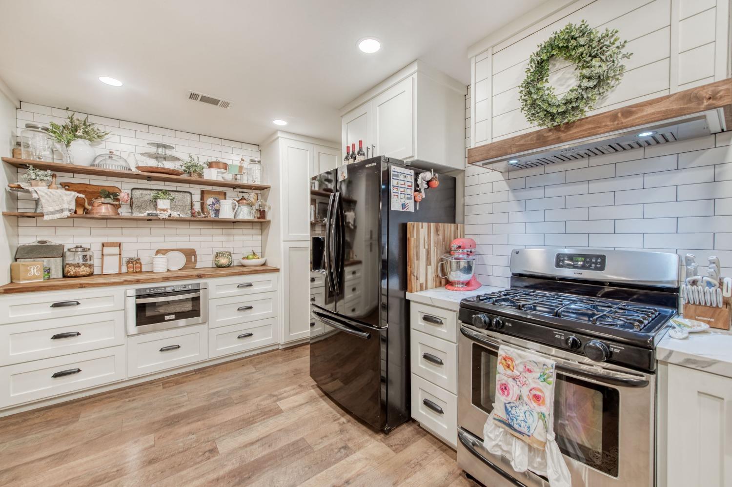 1880 East Cardella Street Firebaugh, CA 93622 - Photo 16 of 42 a kitchen with stainless steel appliances a stove and a refrigerator