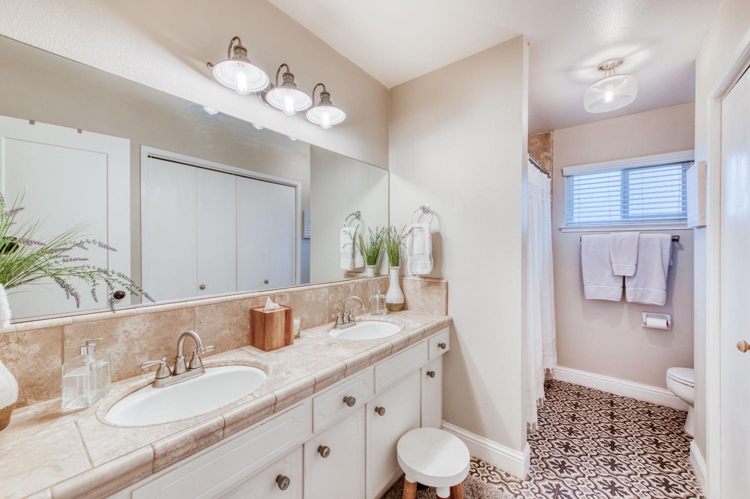 1880 East Cardella Street Firebaugh, CA 93622 - Photo 21 of 42 a bathroom with a granite countertop sink a toilet and a large mirror