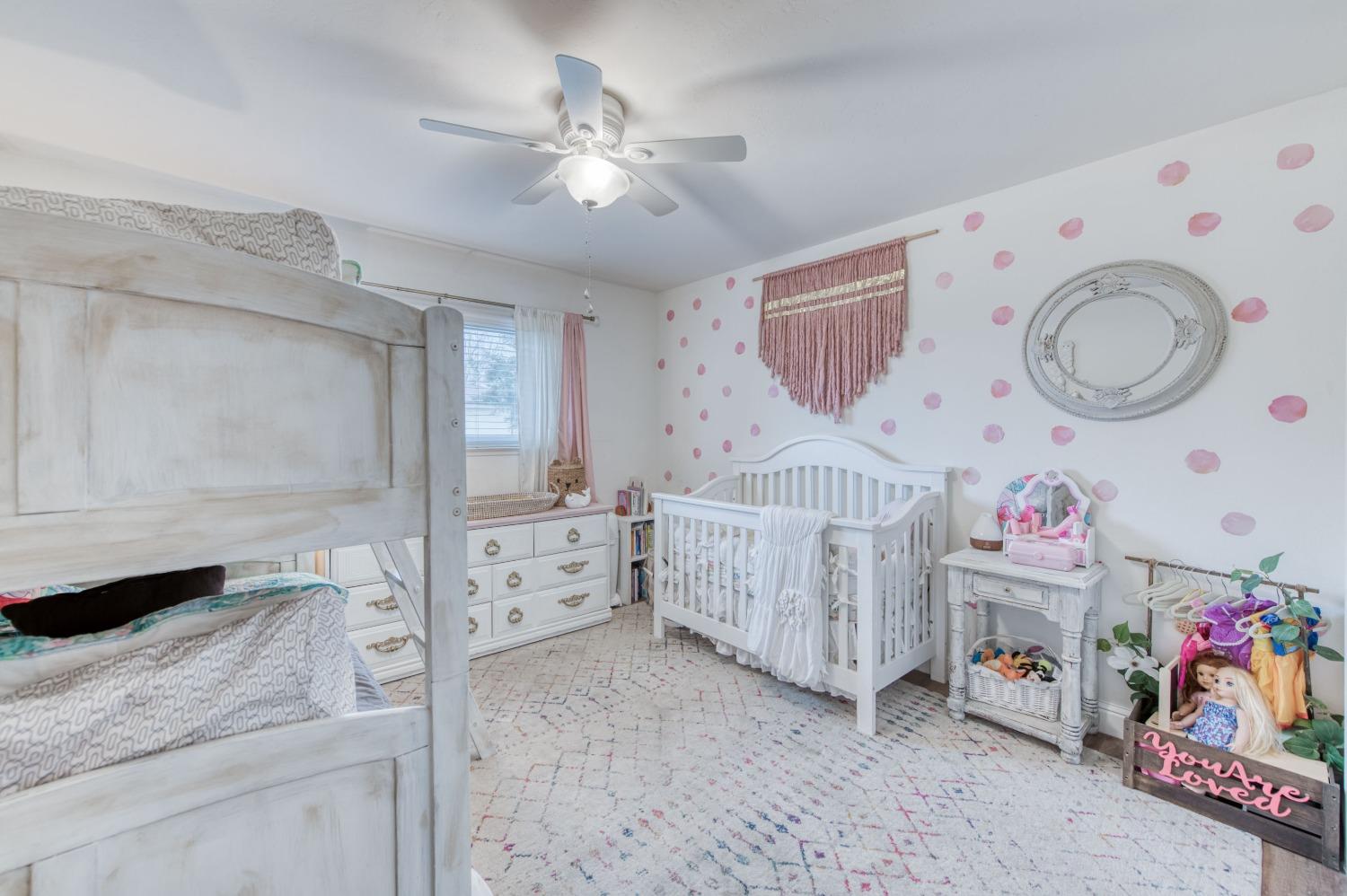 1880 East Cardella Street Firebaugh, CA 93622 - Photo 22 of 42 a bedroom with furniture a baby crib and a window